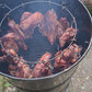 Carne asándose lentamente en barril grande – cocción uniforme y brasa constante