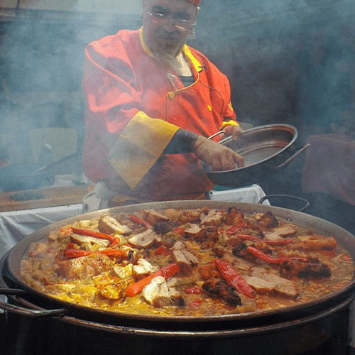 Asador de barril grande en uso con carnes colgando – cocción vertical con sabor ahumado